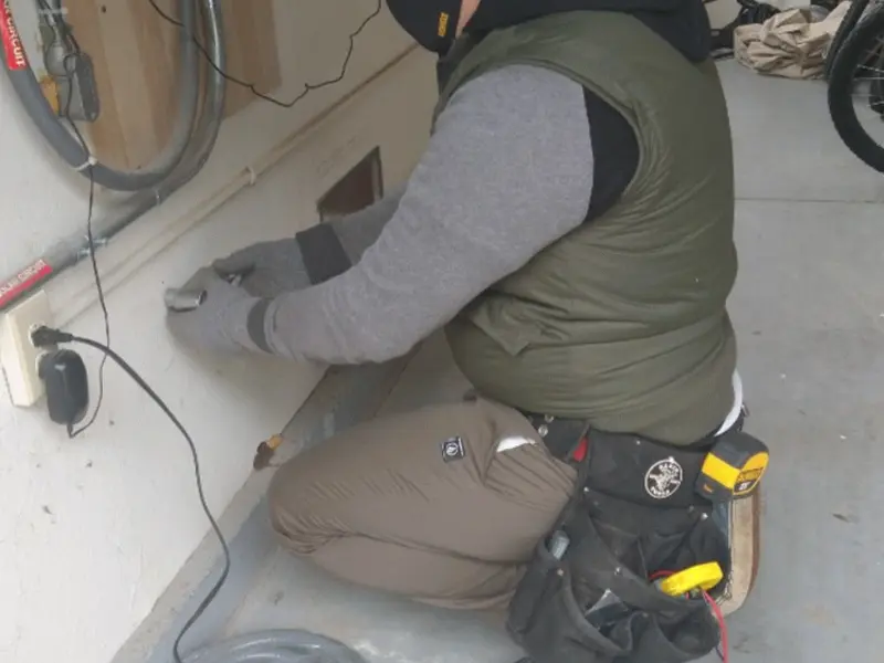 Electrician performing outlet wiring in a Broadmoor garage
